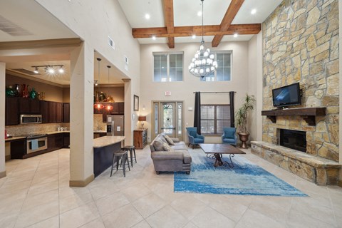 the living room has a large stone fireplace and a blue rug